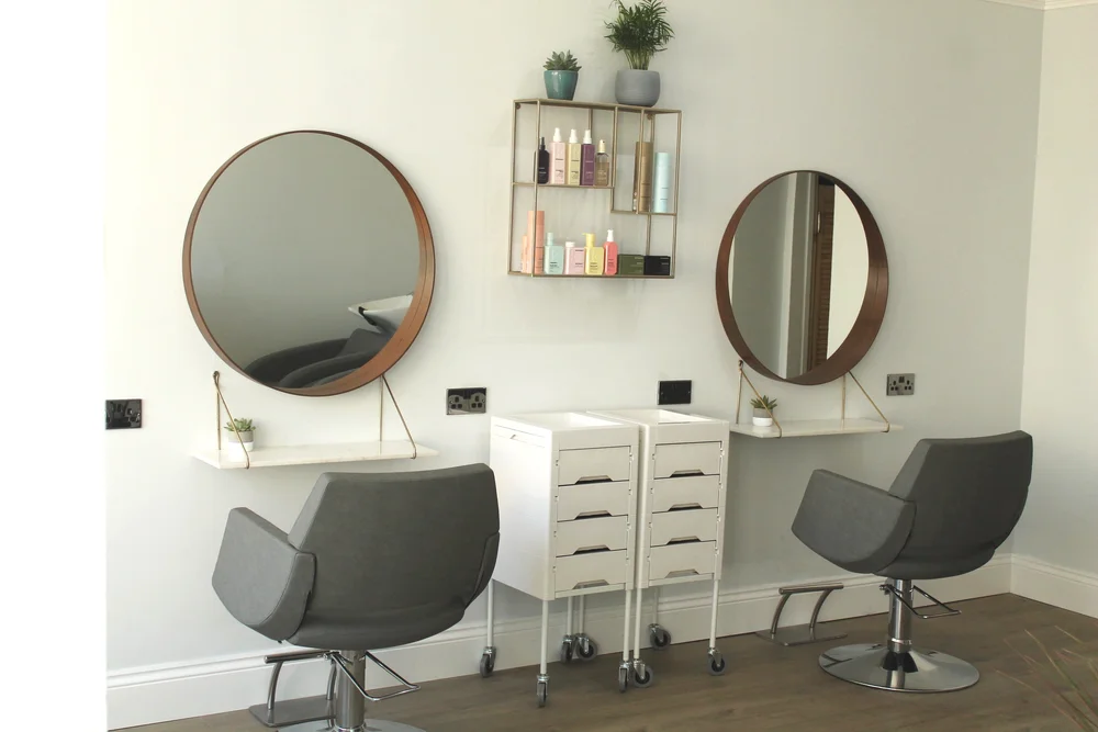 Low and Jones salon styling stations with round copper mirrors